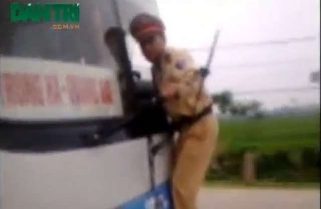 Szolgálat mindenáron: busz orrán csüng a vietnami rendőr