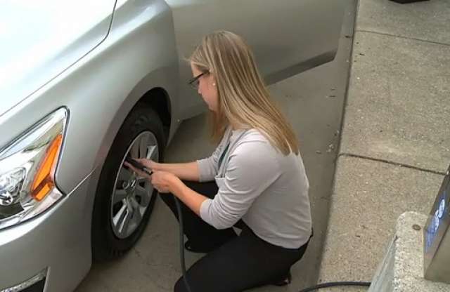 Szőke nő örül az új keréknyomás-ellenőrzőnek